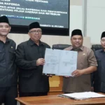 Pimpinan DPRD dan Bupati Sukabumi tunjukan Berita Acara Persetujuan Bersama atas dua Raperda dalam rapat paripurna ke-14. (Sumber : Dok. DPRD)