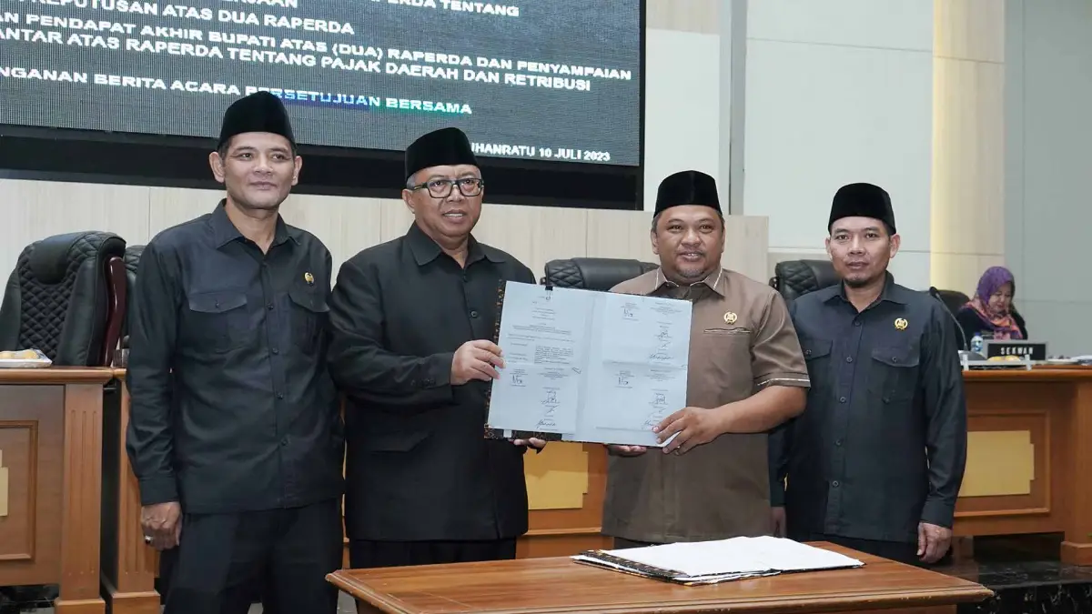Pimpinan DPRD dan Bupati Sukabumi tunjukan Berita Acara Persetujuan Bersama atas dua Raperda dalam rapat paripurna ke-14. (Sumber : Dok. DPRD)